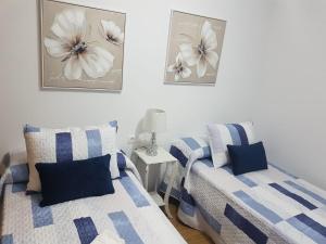 a bedroom with two beds and a table with a lamp at APARTAMENTO A CHILENA in Cambados
