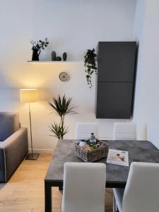 ein Esszimmer mit einem Tisch und weißen Stühlen in der Unterkunft Claro Apartments - Prampolini 12 in Mailand