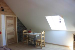 a room with a table and chairs in a attic at Le nid du Kaloui in Fréland