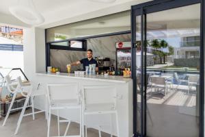 a man standing behind a bar in a restaurant at Epicentrum Suites Fresh in Limenaria