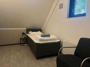 a small room with a bed and two chairs at sfeervol vrijstaand huisje 6 persoons ruime tuin, centraal bij Nijmegen in Ewijk