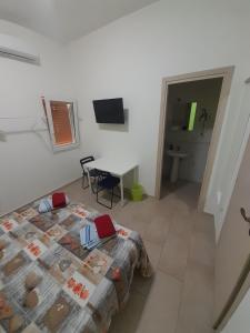 a bedroom with a bed and a table and a bathroom at CTA Catania Aeroporto fontanarossa reception h24 in Catania