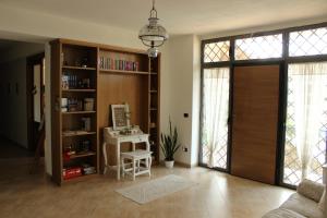 a living room with a door and a desk with a computer at Le Rocce in SantʼAgata deʼ Goti