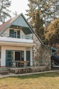 a house with a picnic table on the front porch at Aquilo Apartmanok in Tihany