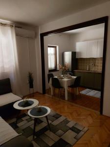 een woonkamer met een tafel en een keuken bij Apartman Luka&Petar in Trebinje +17 foto's