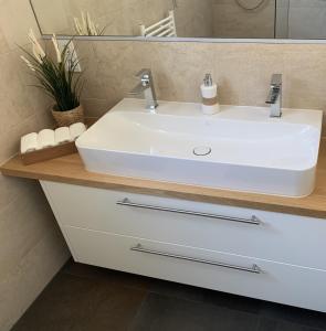 uma casa de banho com um lavatório branco e um espelho. em Haus Astrid em Irrel
