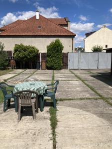 stół piknikowy i dwie ławki na dziedzińcu w obiekcie Apartmán Na Ostrově Beroun w mieście Beroun