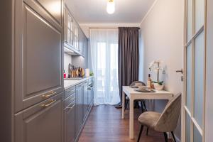 - une cuisine avec une table, une petite table et des chaises dans l'établissement Golden Mirage Sunset Apartment, à Mamaia