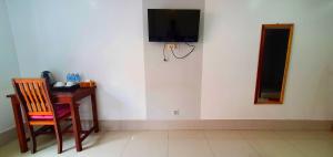 Nary Villa في سيام ريب: غرفة بها مكتب وتلفزيون على الحائط