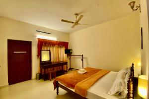 sypialnia z łóżkiem i telewizorem w obiekcie Green View w mieście Thekkady