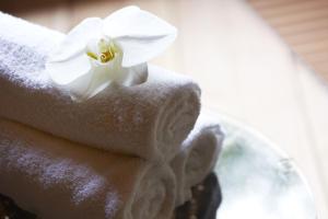a white flower sitting on top of a pile of towels at Fudoguchikan in Izumi-Sano