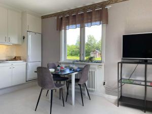 a kitchen with a table and chairs and a television at Fin lägenhet i centrala Oviken, mellan fjäll&stad in Oviken