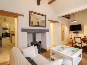 a living room with a fireplace with a couch and a table at Glan Y Mor Lodge in Y Felinheli