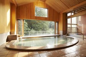 una gran piscina en una habitación con una gran ventana en Fudoguchikan, en Izumisano