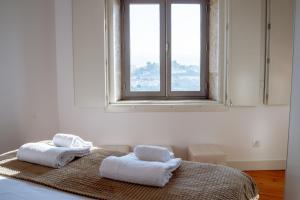 a bedroom with two towels on a bed with a window at Authentic Porto House in Porto +110 photos