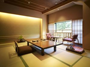 d'un salon avec une table et des chaises ainsi que d'un balcon. dans l'établissement Fudoguchikan, à Izumi-Sano