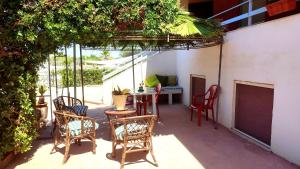 patio z krzesłami, stołem i krzesłami w obiekcie Casavacanze Villa MASHALLAH w mieście Reitani
