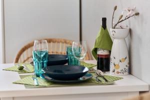 a table with a plate and glasses and a bottle of wine at Apartment By the Oder River Wrocław by Renters in Wrocław