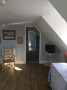 Zimmer im Dachgeschoss mit einem Bett und einem TV in der Unterkunft Barn Flat overlooking beautiful Dorset vale in Sherborne