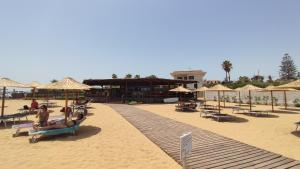 plaża z leżakami i parasolami oraz ludzie na piasku w obiekcie Casavacanze Villa MASHALLAH w mieście Reitani