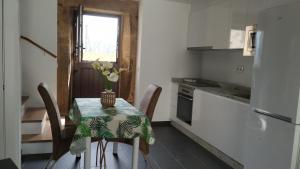 a kitchen with a table with a vase of flowers on it at A xanela in Outes