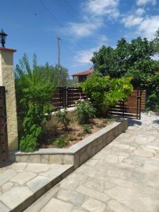 un giardino con alberi e una recinzione in legno di Ioannis Stagkonis House 2 a Ormos Panagias