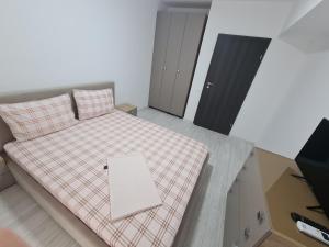 Dormitorio pequeño con cama con manta a cuadros en Apartament Moghioros Park Residence DUM1 en Bucarest