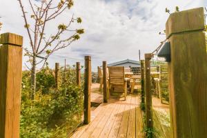 einen Holzsteg in einem Garten mit einem Zaun in der Unterkunft Raddicombe Lodge in Brixham