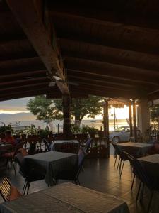 a restaurant with tables and chairs and a car in the background at Restaurant & Apartments Lipa in Peštani