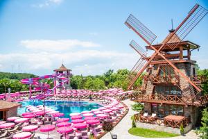 uma piscina num resort com guarda-sóis cor-de-rosa e um parque aquático em The Wind Mills Hydropark em Gorna Malina
