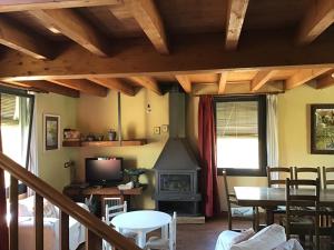a living room with a fireplace and a stove at El Molí de Cal Pastisser in Avellanes