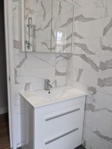 a white bathroom with a sink and a mirror at West Kensington in London
