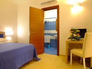 a bedroom with a bed and a desk and a chair at Agriturismo L'Angela in Borgagne +5 photos