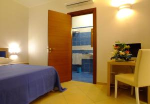 a bedroom with a bed and a desk and a chair at Agriturismo L'Angela in Borgagne
