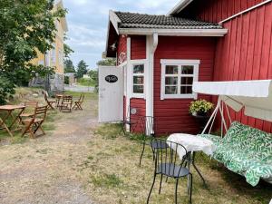 a red building with chairs and a table and chairs at Vinter Bed & Breakfast in Sauvo