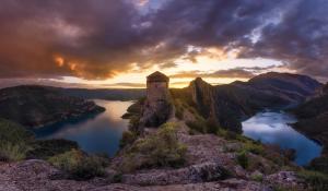 un castillo en la cima de una montaña con un lago en El Molí de Cal Pastisser, en Avellanes