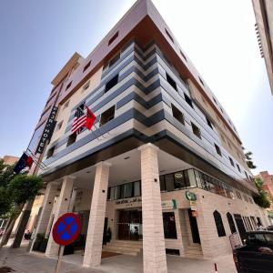 a building with a flag on top of it at Fajr Hotel in Oujda