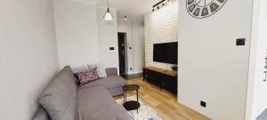 a living room with a couch and a flat screen tv at Central Apartments Ogarna 4 in Gdańsk