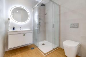 a white bathroom with a shower and a toilet at 7 Mares in Póvoa de Varzim