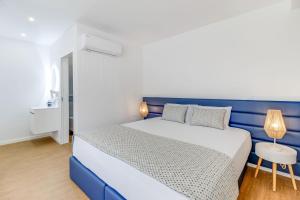 a blue and white bedroom with a bed and a table at 7 Mares in Póvoa de Varzim
