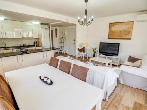 a living room with a table and a kitchen at Clarimar Beach Apartment by Hello Homes Sitges in Sitges
