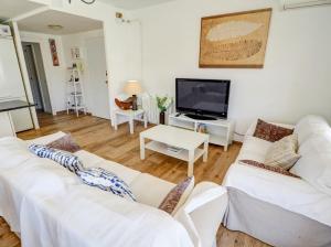 a living room with two white couches and a flat screen tv at Clarimar Beach Apartment by Hello Homes Sitges in Sitges +18 photos