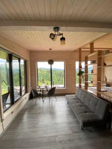 a living room with a couch and a table with chairs at Ecottage котедж для двох у горах із чаном-джакузі in Slavske