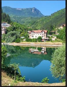 a view of a lake with houses and a mountain at Nera-etwa Konjic 2 room in Konjic