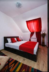 a bedroom with a large bed with red curtains at Nera-etwa Konjic 2 room in Konjic