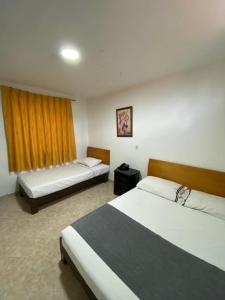 una camera d'albergo con due letti e una finestra di Hotel Gran Imperio a Medellín