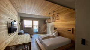 a bedroom with a bed and a desk and a television at Ferienwohungen Wedl in Kleinarl