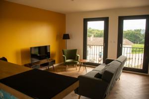a living room with a couch and a television at Vandenbeld Wines B&B in Minzac