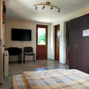 a bedroom with a bed and a flat screen tv at Casa Luna in Gura Humorului +31 photos