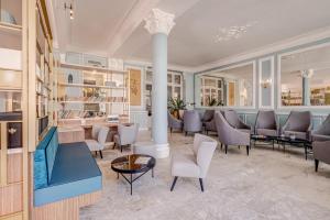 a salon with chairs and tables and a column at Hôtel Miléade L'Orangeraie - Menton in Menton